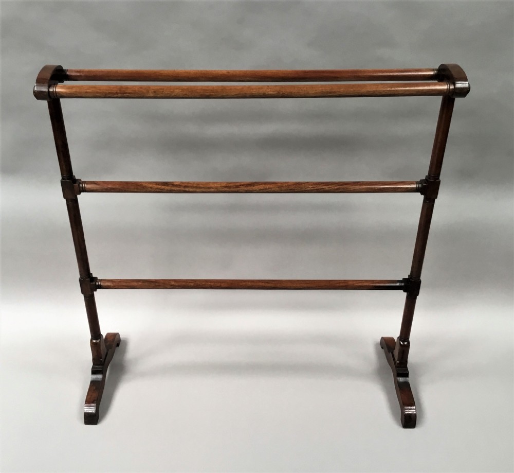 A Regency mahogany freestanding towel rail featuring turned horizontal rails and sledge feet. View II