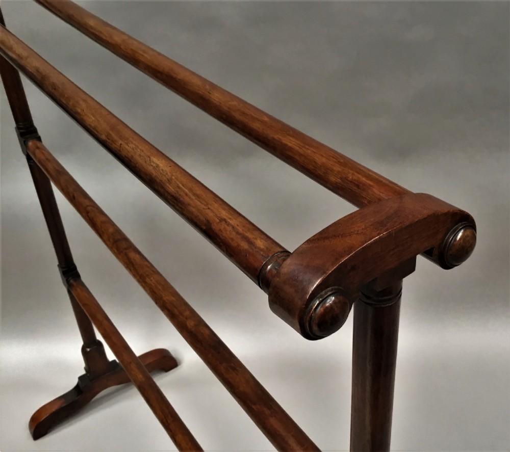 A Regency mahogany freestanding towel rail featuring turned horizontal rails and sledge feet. View IV