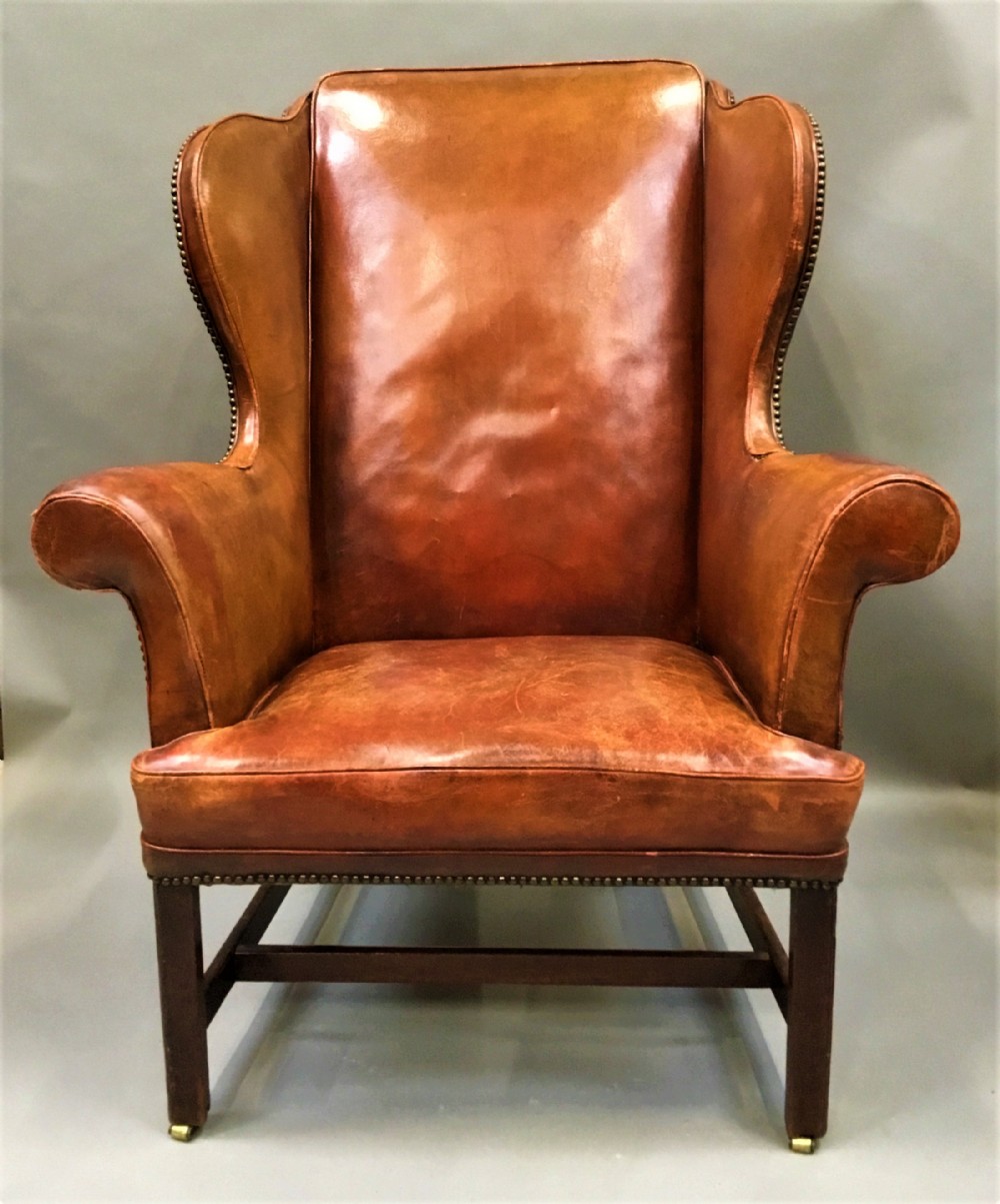 George III mahogany and leather wing chair of generous proportions