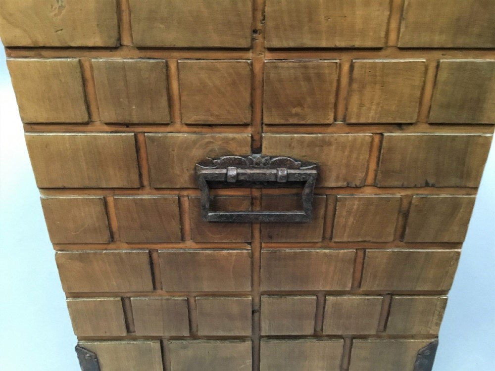 An 18th-century Spanish walnut low cabinet featuring a brick-patterned wooden facade, iron corner brackets, side handles, and multiple drawers with small brass knobs. View XIV