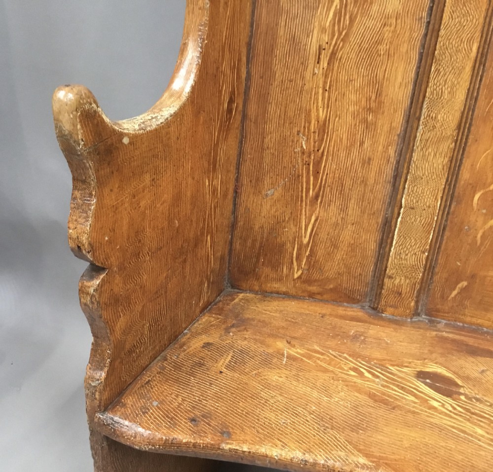 An antique Georgian high-backed wooden settle featuring a curved panelled back with a warm brown scumbled painted finish and integrated seat. View V