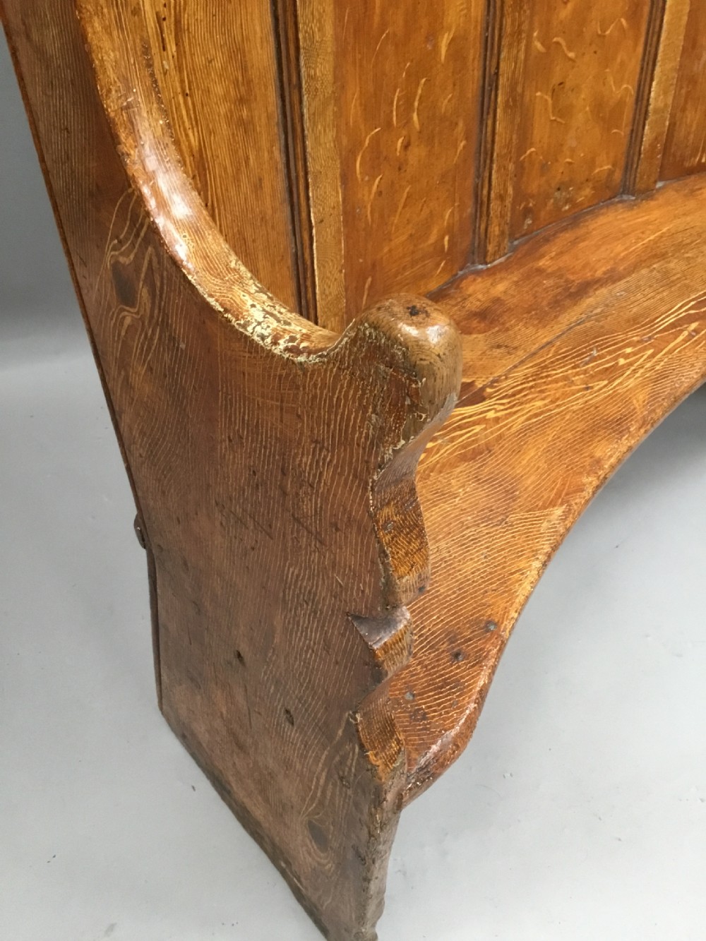 An antique Georgian high-backed wooden settle featuring a curved panelled back with a warm brown scumbled painted finish and integrated seat. View X