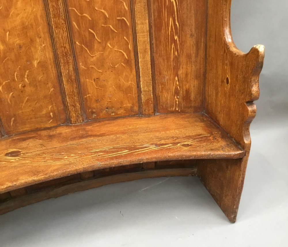 An antique Georgian high-backed wooden settle featuring a curved panelled back with a warm brown scumbled painted finish and integrated seat. View XIV