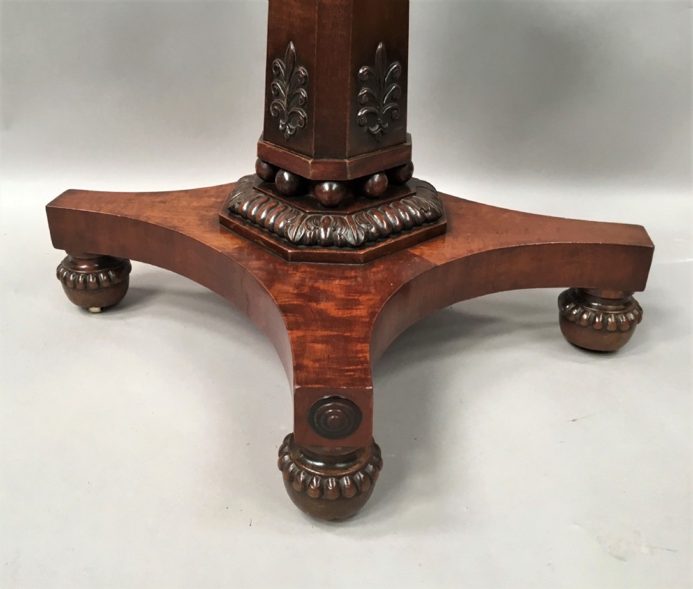 A Regency mahogany centre table featuring a rounded square top with rope-twist carved moulding, supported by a central tapered pedestal and a quadform base with lobed feet. View IX