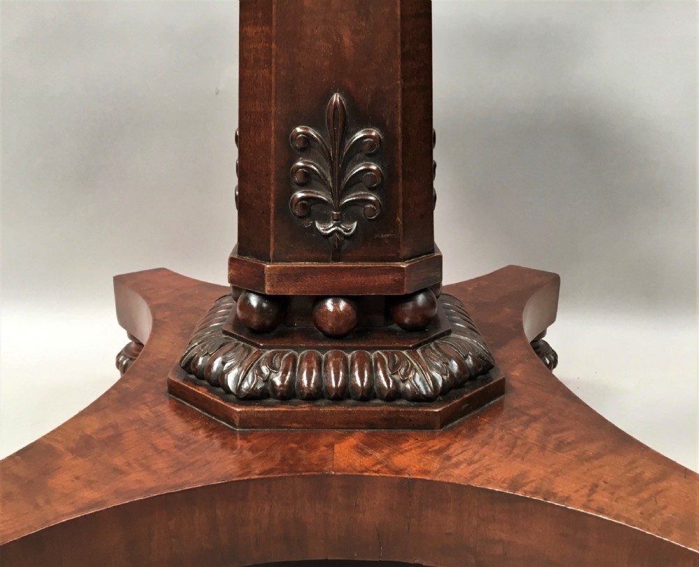 A Regency mahogany centre table featuring a rounded square top with rope-twist carved moulding, supported by a central tapered pedestal and a quadform base with lobed feet. View XII