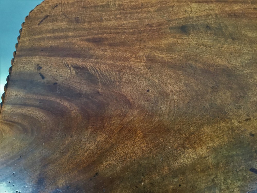 A Regency mahogany centre table featuring a rounded square top with rope-twist carved moulding, supported by a central tapered pedestal and a quadform base with lobed feet. View XVI