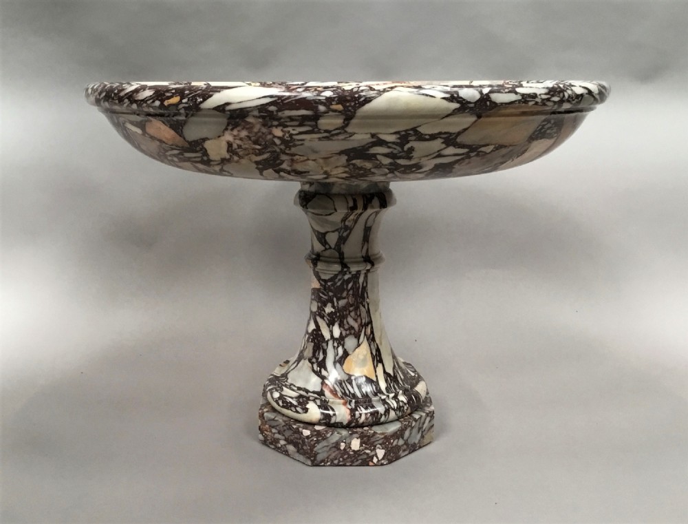 A large 19th-century Neoclassical tazza carved from variegated brecciated marble featuring a shallow wide bowl on a turned stem and octagonal base. View X