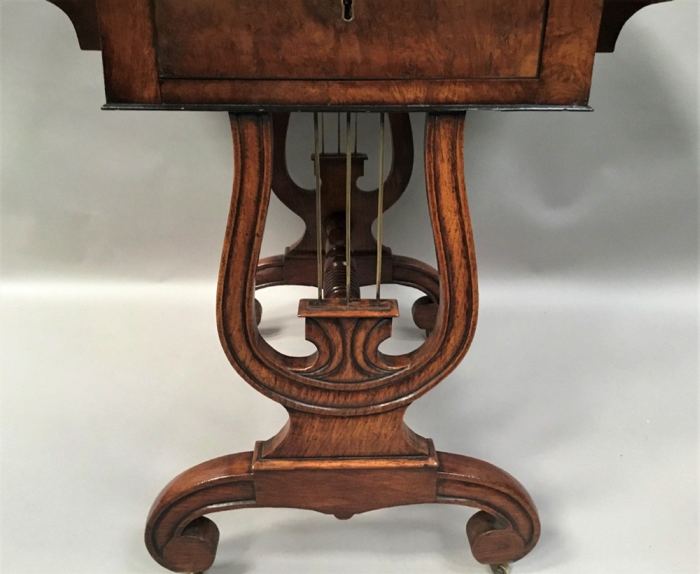 A Regency burr oak drop-flap occasional table featuring lyre-shaped side supports, a single drawer, turned stretcher, and brass castors. View V