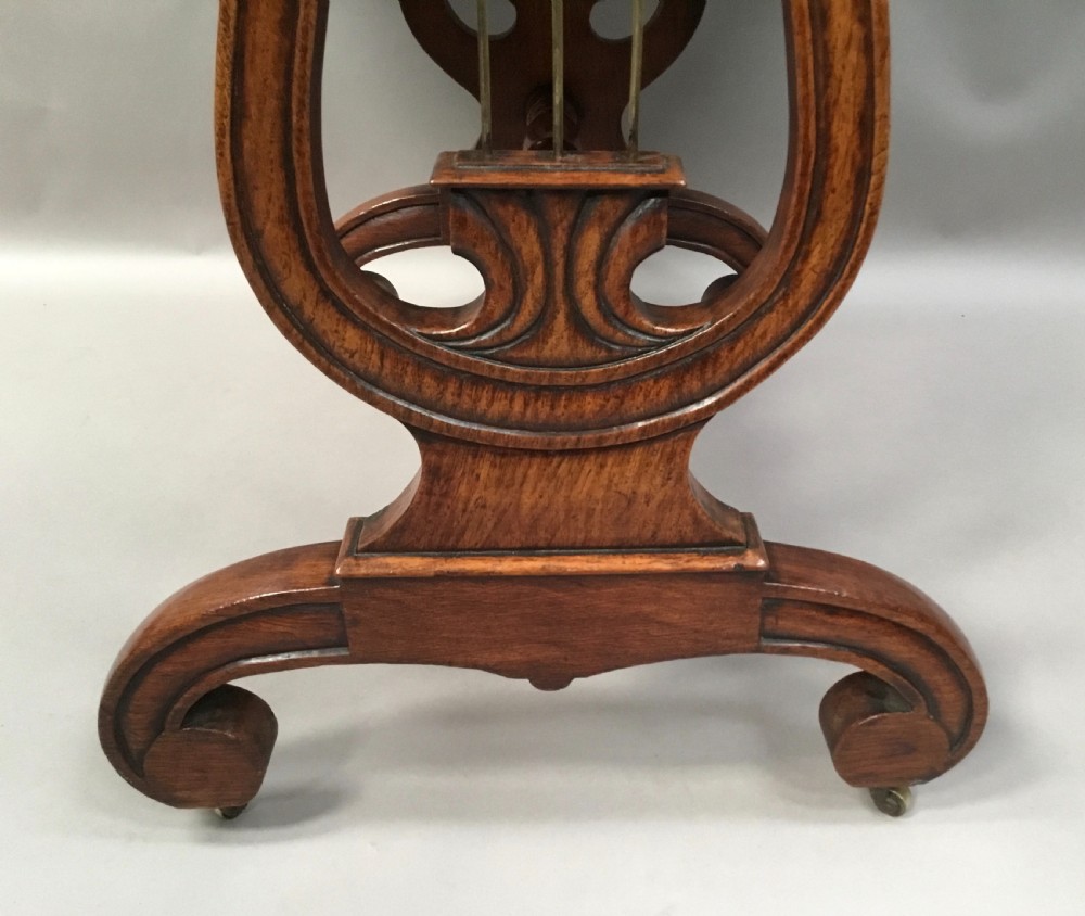 A Regency burr oak drop-flap occasional table featuring lyre-shaped side supports, a single drawer, turned stretcher, and brass castors. View XI