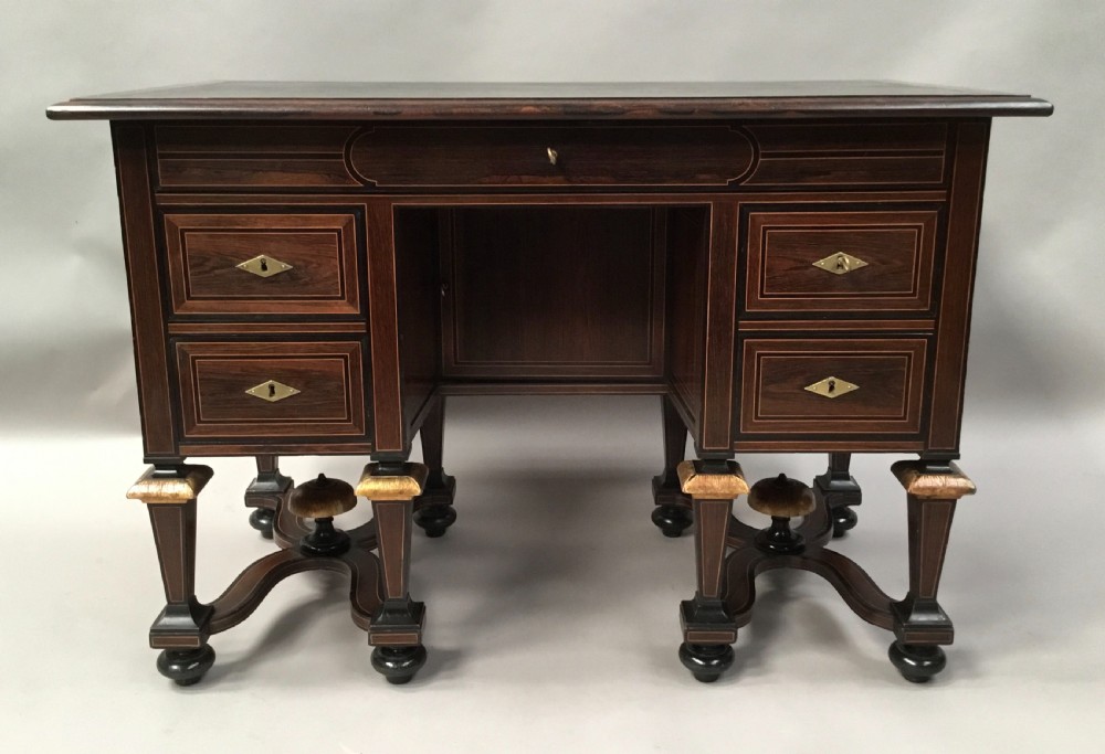 A 19th-century French rosewood kneehole desk featuring line inlay, brass escutcheons, a central recessed cupboard, and eight tapered legs connected by curved stretchers. View III