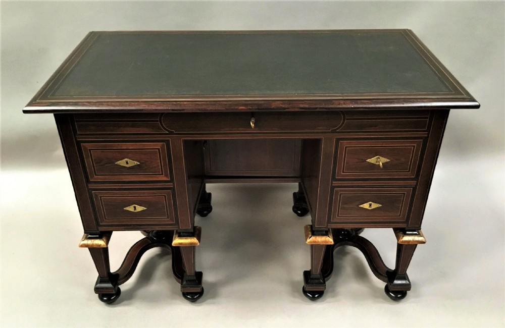 A 19th-century French rosewood kneehole desk featuring line inlay, brass escutcheons, a central recessed cupboard, and eight tapered legs connected by curved stretchers. View IV