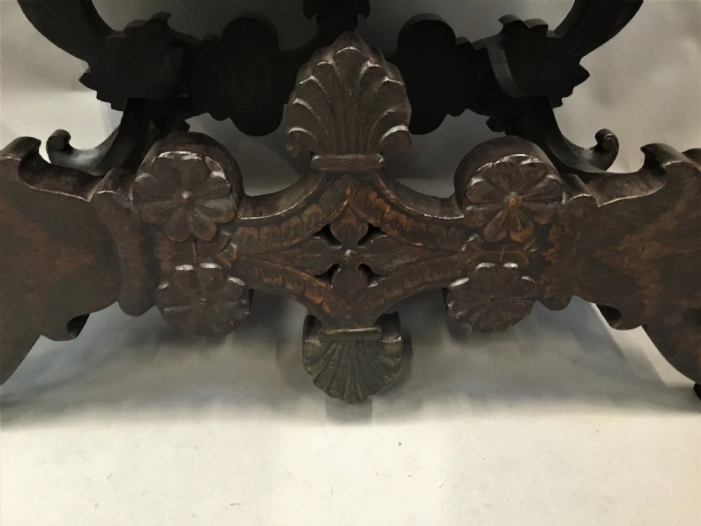A dark brown rectangular lacquered wooden chest decorated with all-over floral pattern, set on a deeply carved scrolled wooden stand. View VII