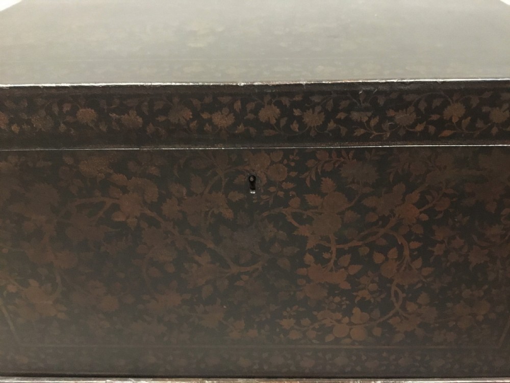 A dark brown rectangular lacquered wooden chest decorated with all-over floral pattern, set on a deeply carved scrolled wooden stand. View XIV