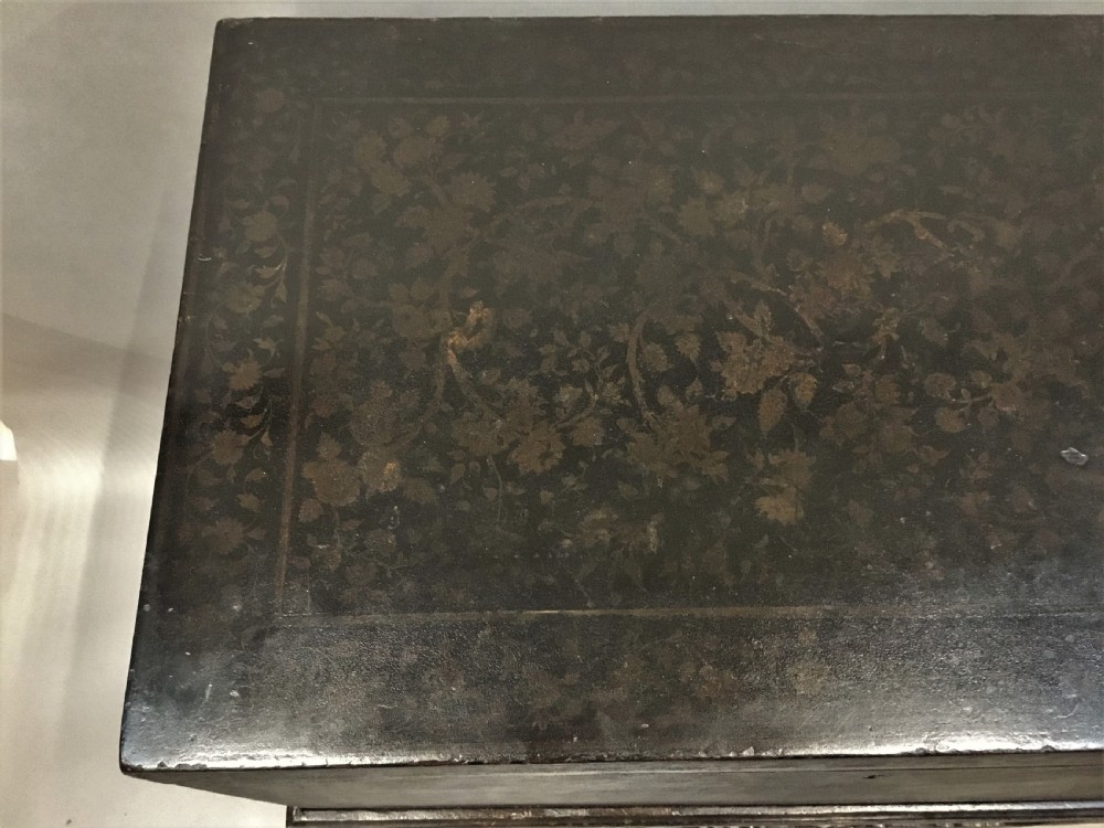 A dark brown rectangular lacquered wooden chest decorated with all-over floral pattern, set on a deeply carved scrolled wooden stand. View XVI