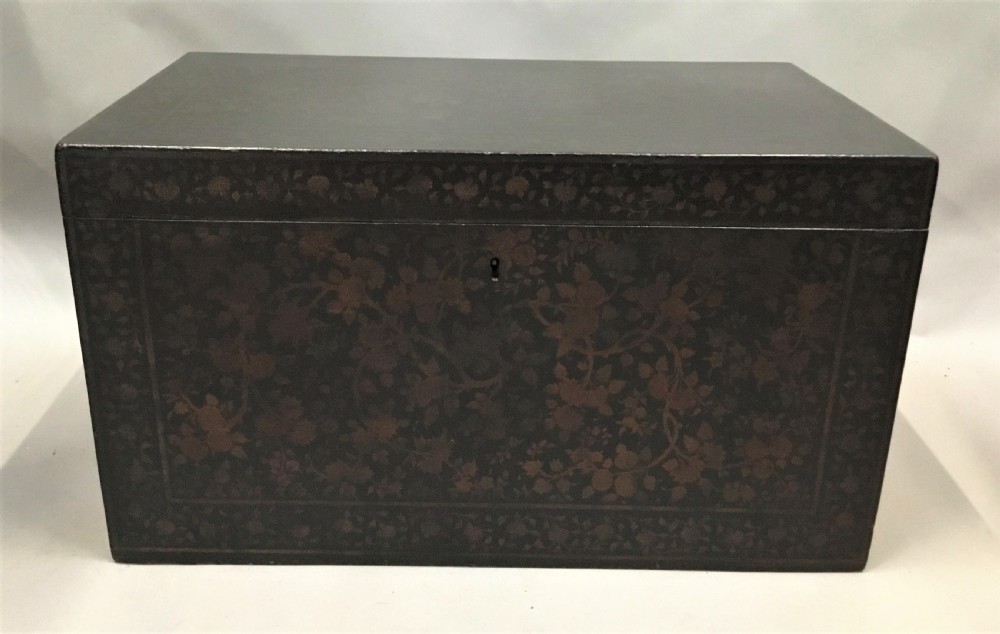 A dark brown rectangular lacquered wooden chest decorated with all-over floral pattern, set on a deeply carved scrolled wooden stand. View XIX