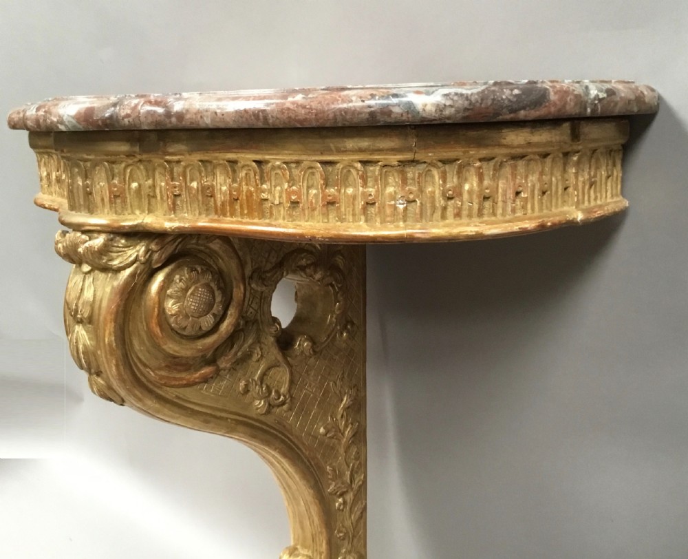 A 19th-century French Louis XV style wall-mounted giltwood console table featuring a carved single scroll leg and a shaped pink marble top. View XI