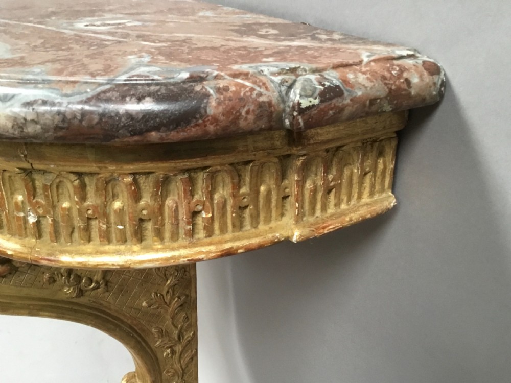 A 19th-century French Louis XV style wall-mounted giltwood console table featuring a carved single scroll leg and a shaped pink marble top. View XII