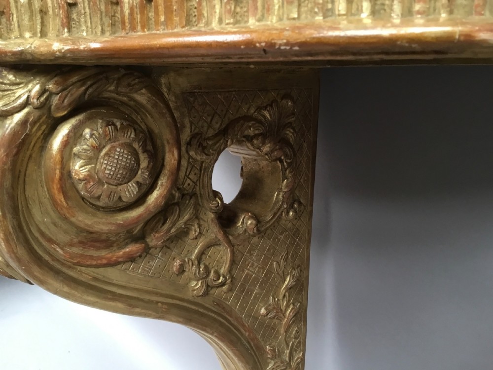 A 19th-century French Louis XV style wall-mounted giltwood console table featuring a carved single scroll leg and a shaped pink marble top. View XIII