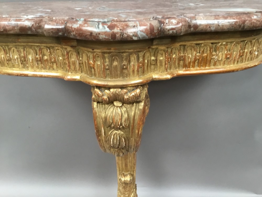 A 19th-century French Louis XV style wall-mounted giltwood console table featuring a carved single scroll leg and a shaped pink marble top. View XIV