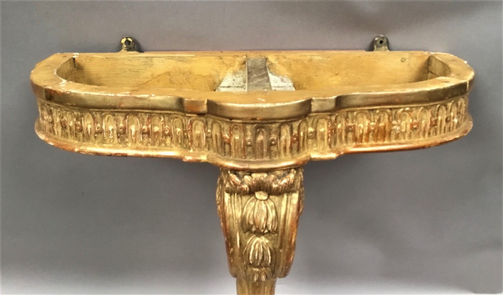 A 19th-century French Louis XV style wall-mounted giltwood console table featuring a carved single scroll leg and a shaped pink marble top. View XV