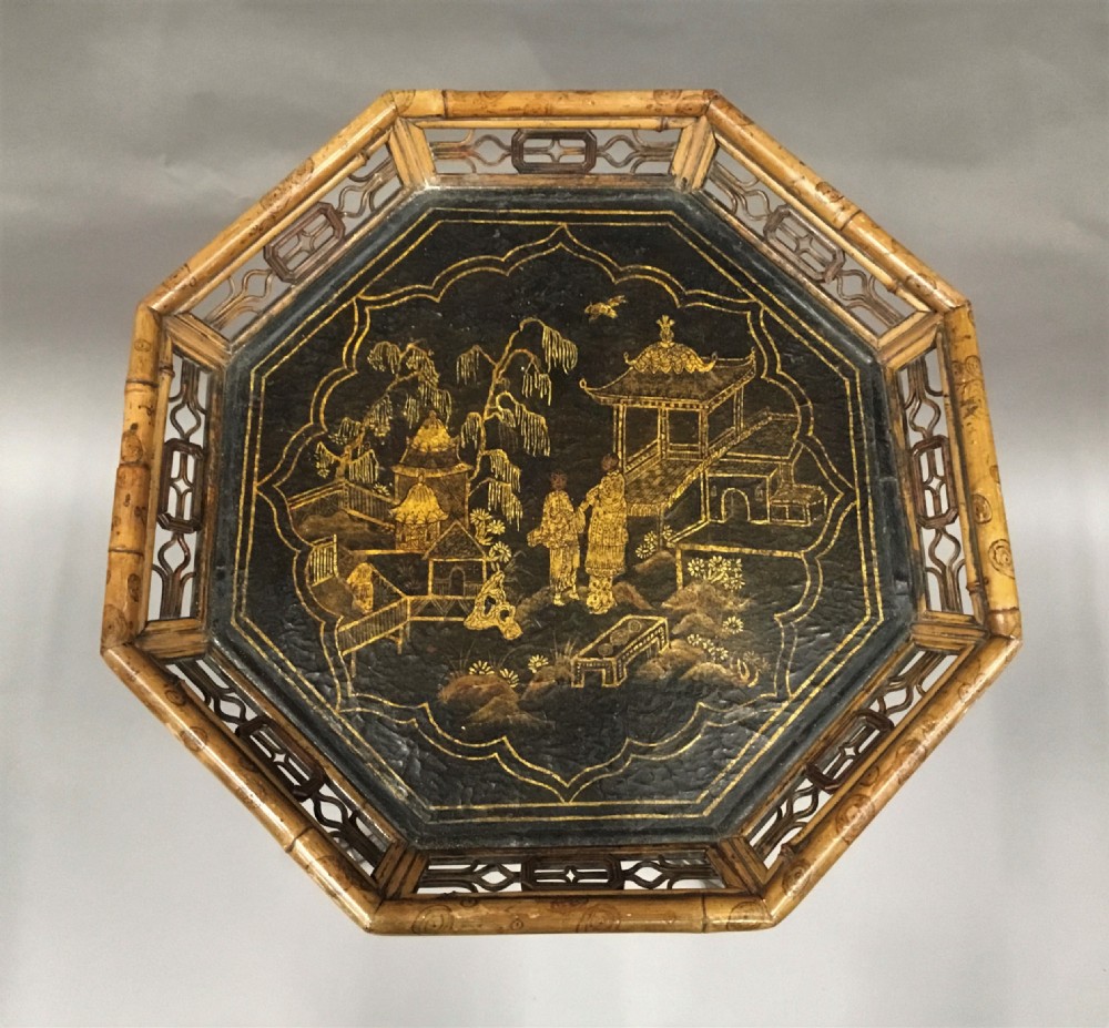 A tall Regency period octagonal torchere stand featuring a black and gold lacquered tray top, reeded column, and tripod base. View II