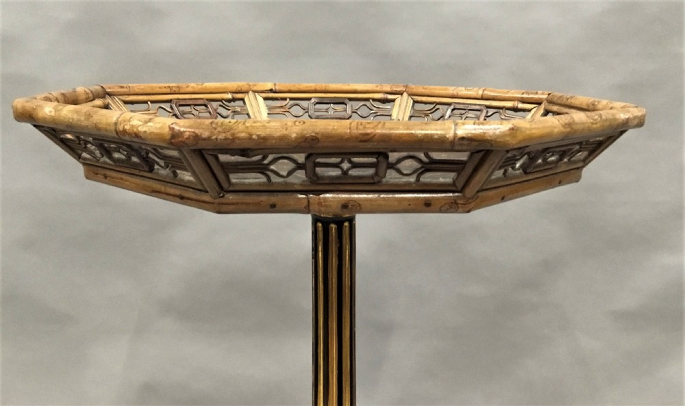 A tall Regency period octagonal torchere stand featuring a black and gold lacquered tray top, reeded column, and tripod base. View X