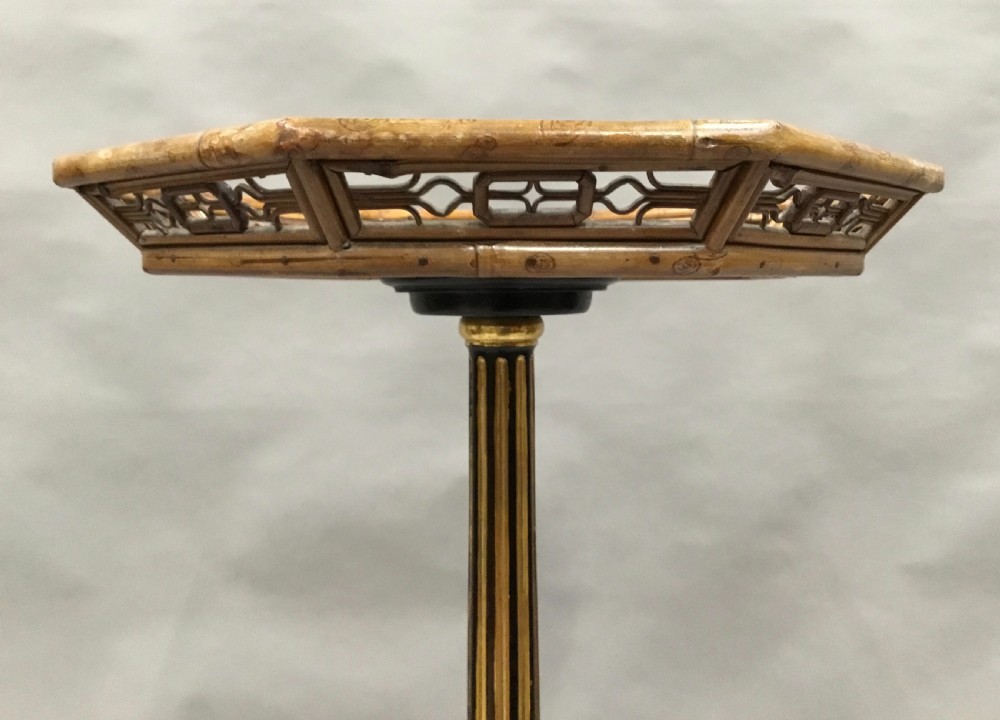 A tall Regency period octagonal torchere stand featuring a black and gold lacquered tray top, reeded column, and tripod base. View XVI