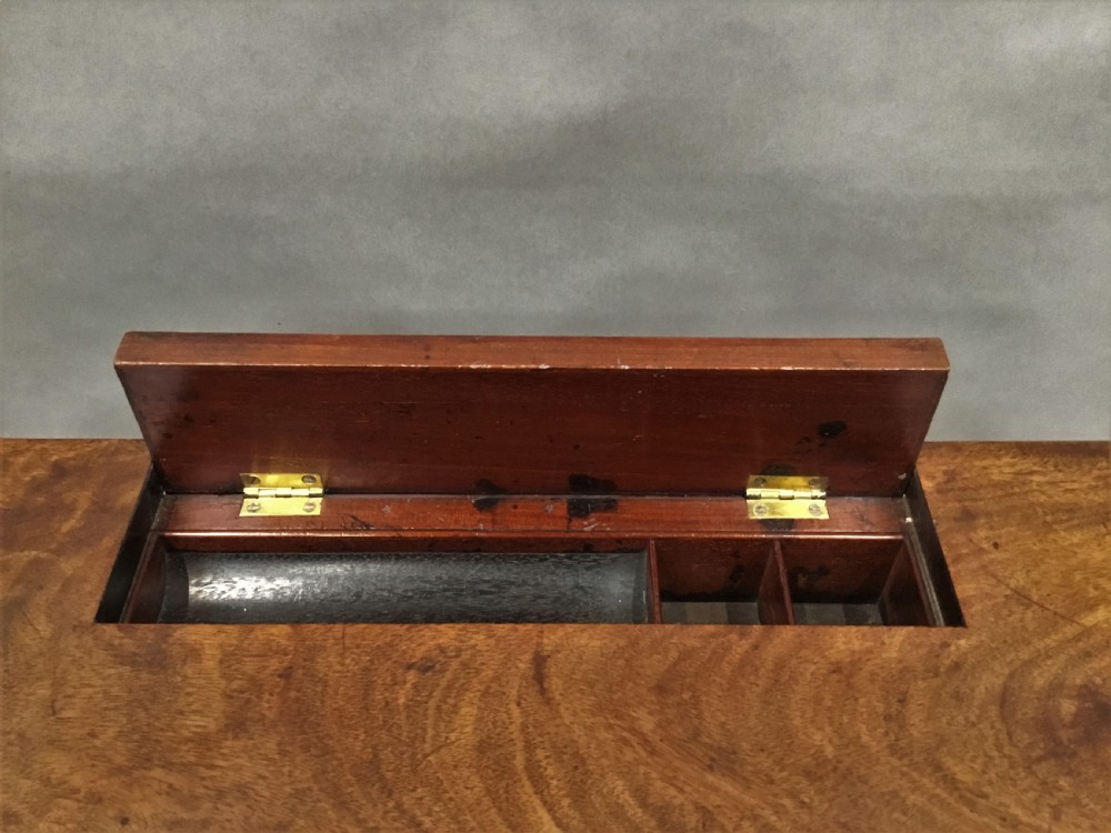 A Regency mahogany writing table featuring an adjustable hinged top, a single drawer with turned knobs, a turned central pedestal, and reeded tripod legs ending in brass castors. View IX