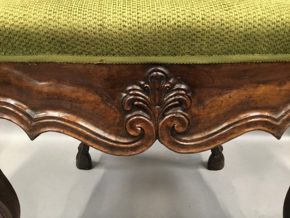 An 18th-century Italian carved walnut open armchair featuring a high upholstered backrest and seat in sage green textured fabric with cabriole legs. View XVIII
