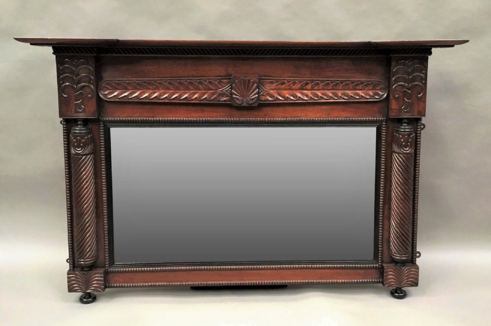 An antique Anglo-Indian carved teak overmantel mirror with spiral-turned columns, shell carving, and a wide rectangular glass panel. View II