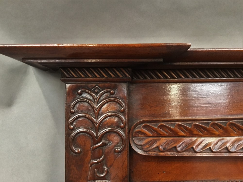 An antique Anglo-Indian carved teak overmantel mirror with spiral-turned columns, shell carving, and a wide rectangular glass panel. View XV