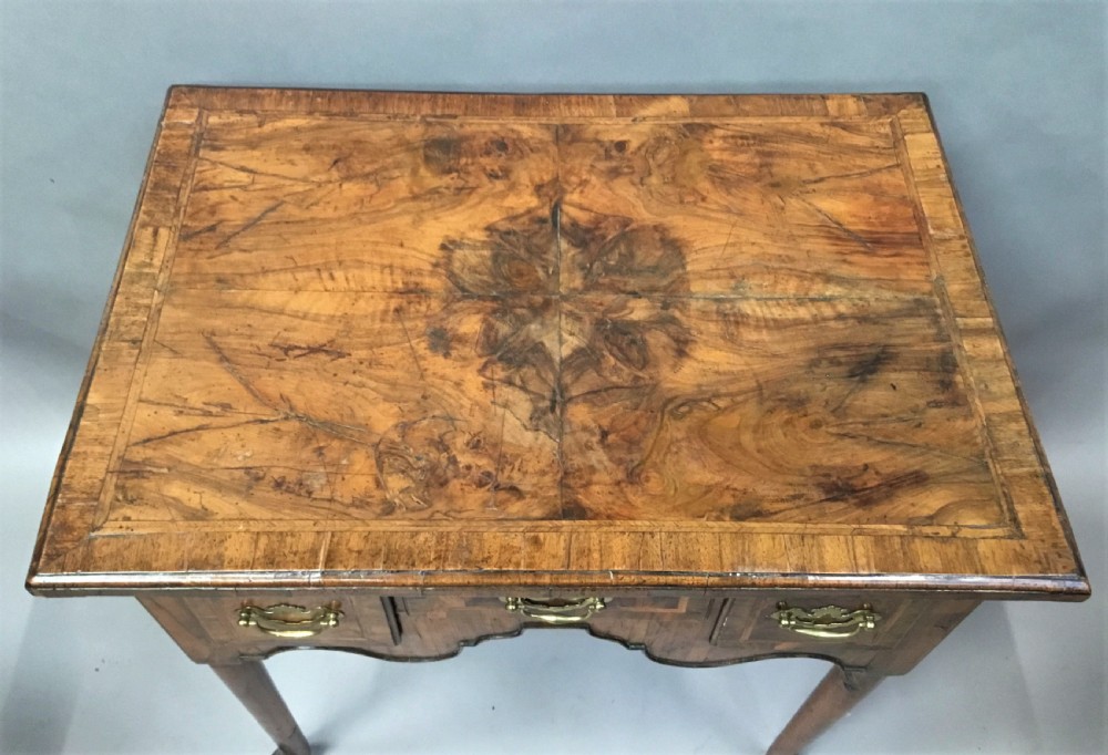 An 18th-century George I figured walnut lowboy with three drawers, brass handles, a shaped apron, and slender cabriole legs with pad feet. View III