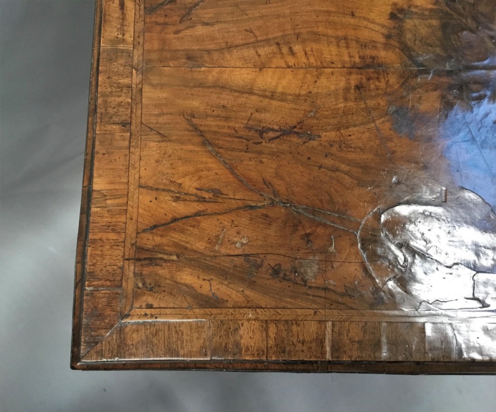 An 18th-century George I figured walnut lowboy with three drawers, brass handles, a shaped apron, and slender cabriole legs with pad feet. View VII