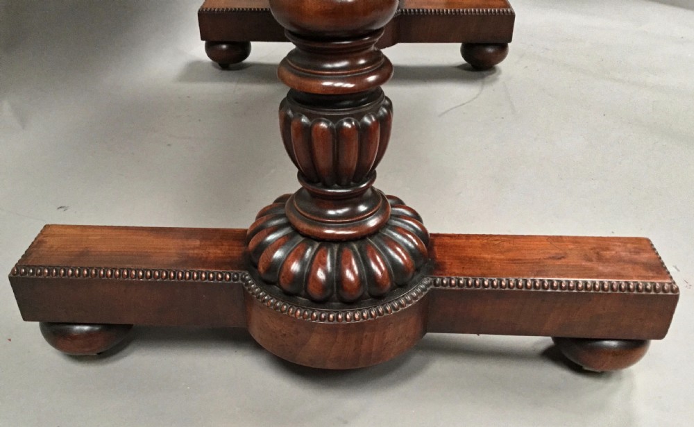 A Regency mahogany library table featuring a carved gadrooned border, reeded turned legs, and a trestle base with feet. View XIII
