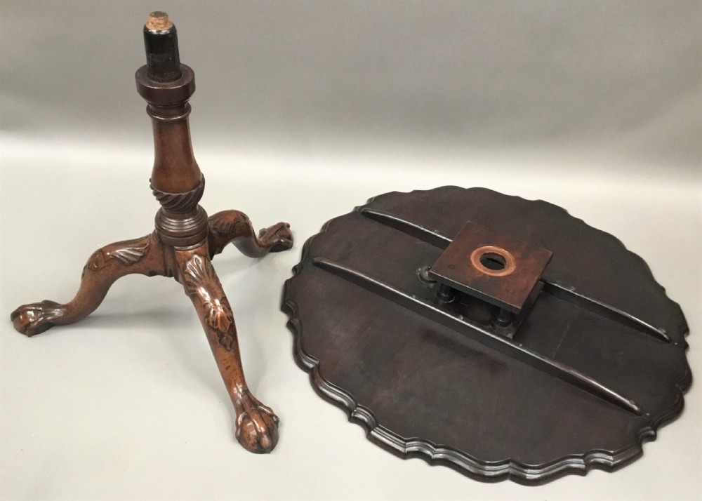 A mahogany George III style tripod table featuring a scalloped piecrust top, turned pedestal column, and cabriole legs with carved feet. View IX