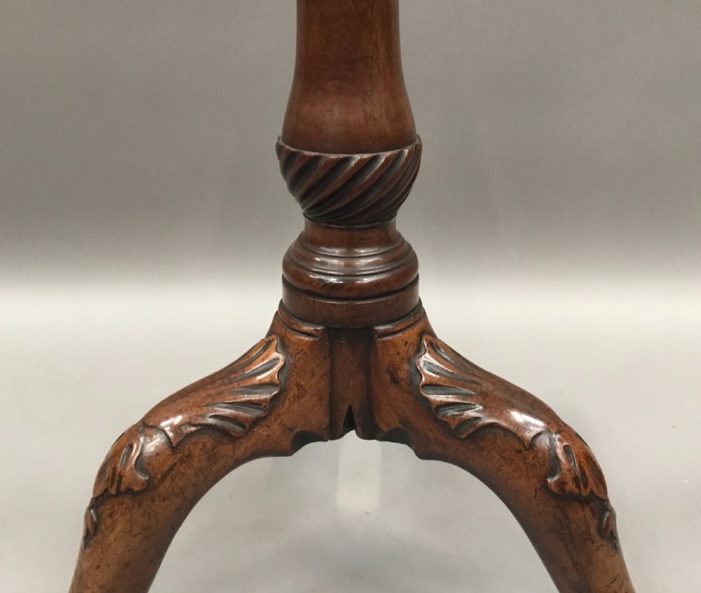 A mahogany George III style tripod table featuring a scalloped piecrust top, turned pedestal column, and cabriole legs with carved feet. View XIV