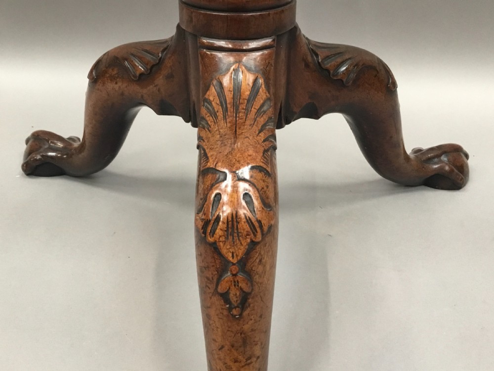 A mahogany George III style tripod table featuring a scalloped piecrust top, turned pedestal column, and cabriole legs with carved feet. View XV