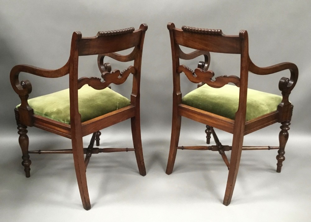 A pair of Regency mahogany open armchairs featuring scrolled armrests, turned front legs, and olive green velvet upholstered seats. View V