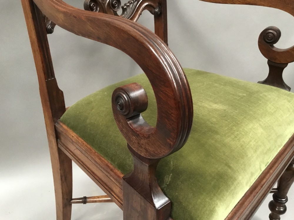 A pair of Regency mahogany open armchairs featuring scrolled armrests, turned front legs, and olive green velvet upholstered seats. View X