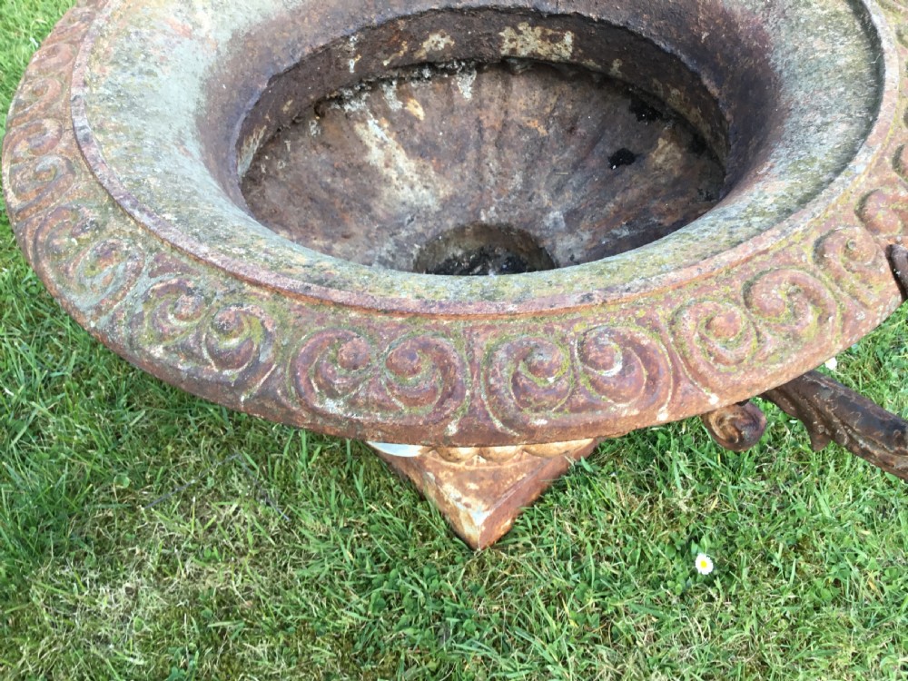 A pair of weathered 19th-century cast iron garden urns of shallow campana form with large scroll handles and square pedestal bases. View VII