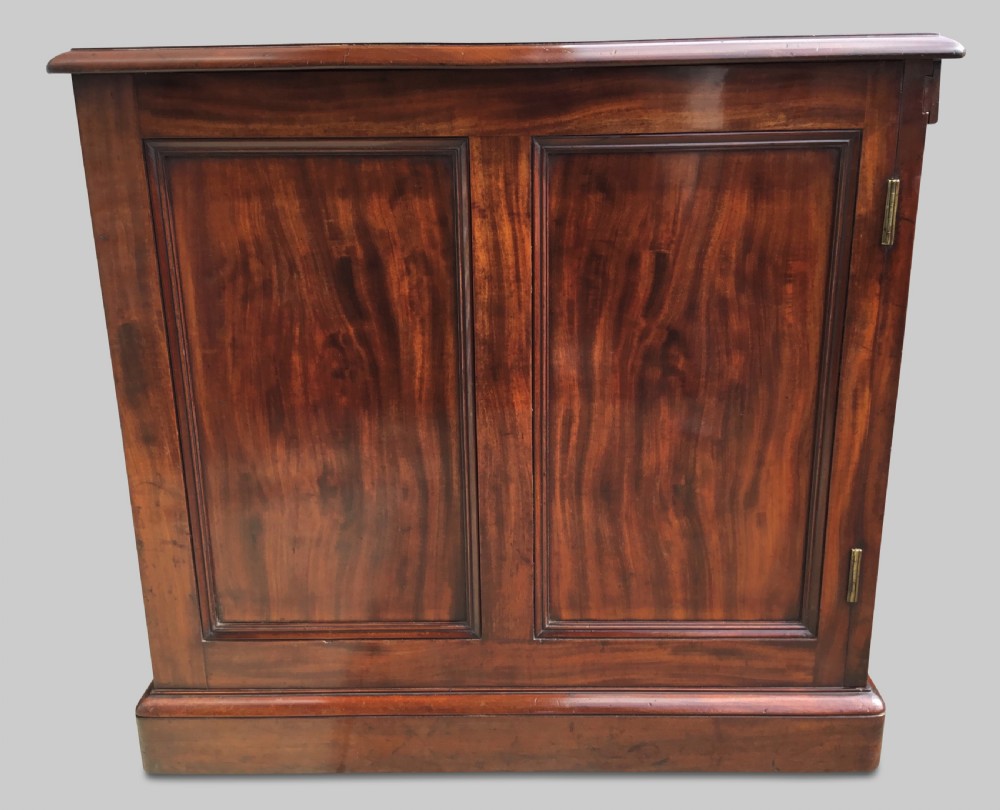 A Regency flame mahogany pedestal desk with an inset brown leather top, multiple drawers with turned wooden knobs, and twin panelled pedestals. View VI