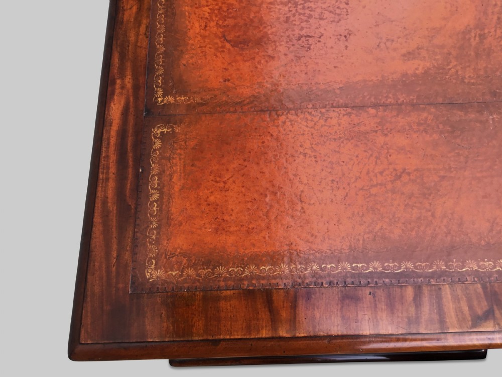 A Regency flame mahogany pedestal desk with an inset brown leather top, multiple drawers with turned wooden knobs, and twin panelled pedestals. View XIV