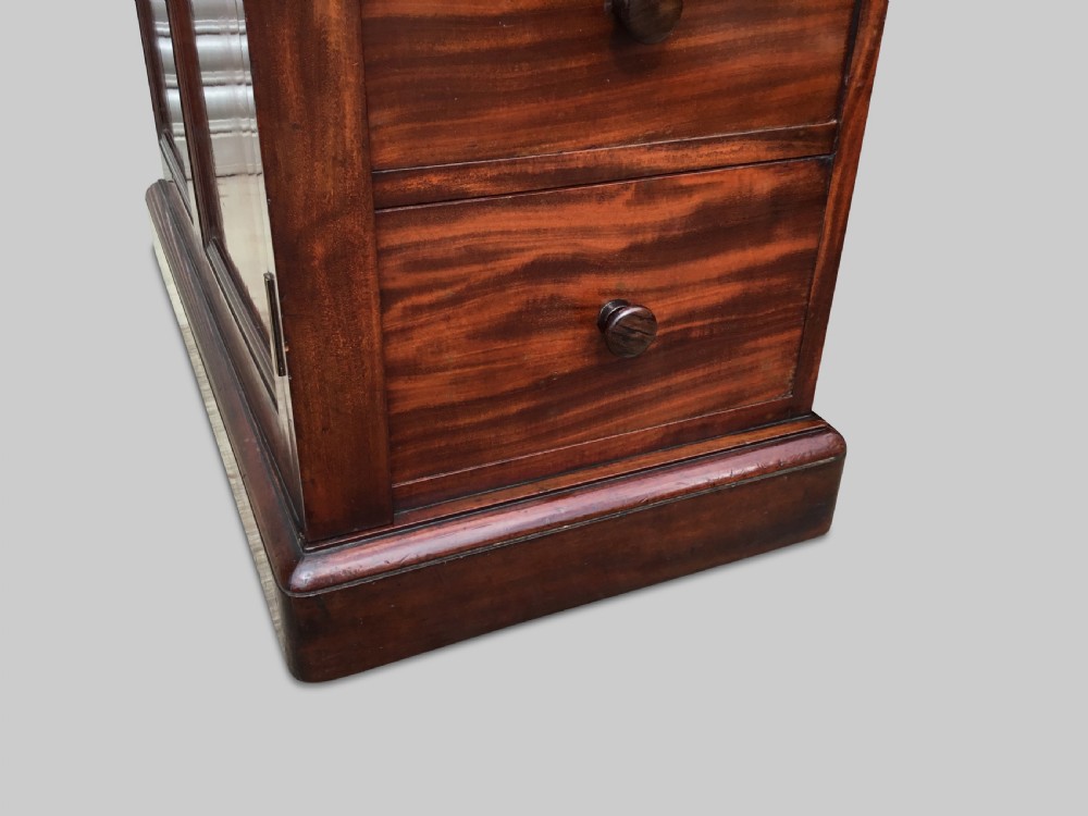 A Regency flame mahogany pedestal desk with an inset brown leather top, multiple drawers with turned wooden knobs, and twin panelled pedestals. View XXVII
