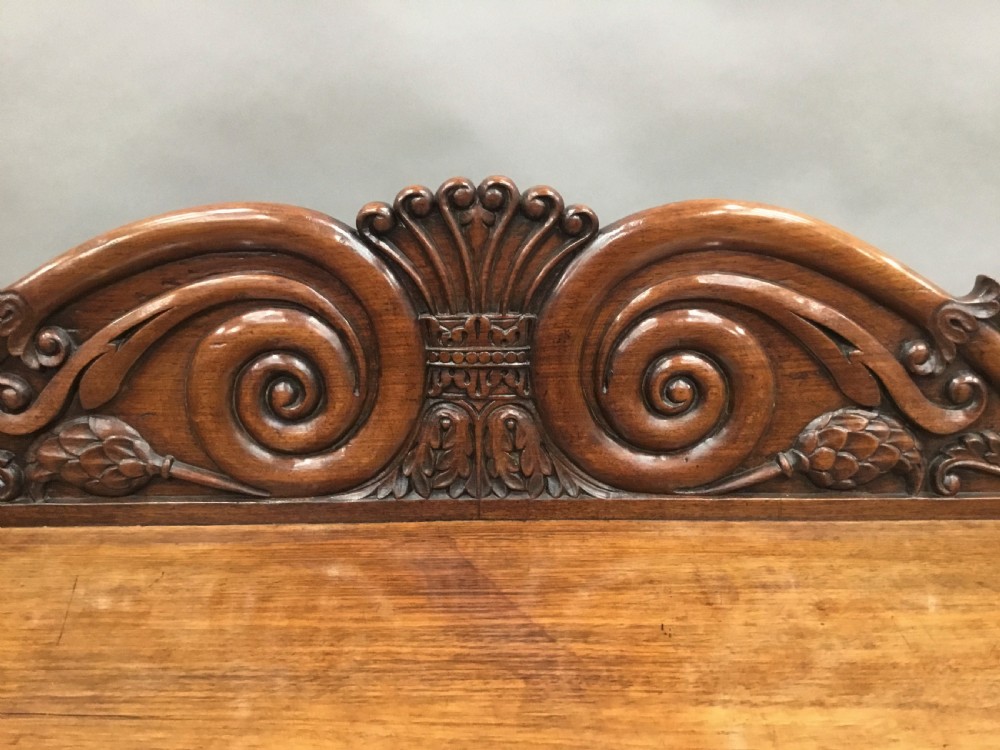 A 19th-century carved padouk console table featuring S-scroll legs, paw feet, a sunburst carved back panel, and a scrollwork gallery upstand. View VI