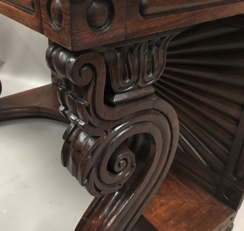 A 19th-century carved padouk console table featuring S-scroll legs, paw feet, a sunburst carved back panel, and a scrollwork gallery upstand. View XV