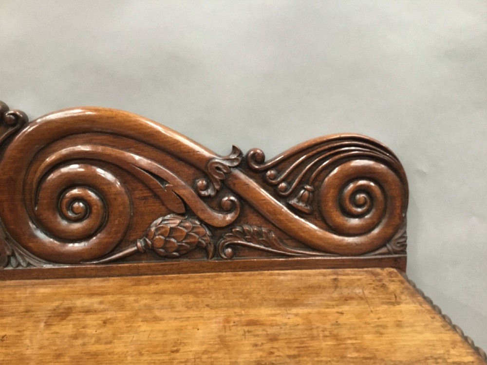 A 19th-century carved padouk console table featuring S-scroll legs, paw feet, a sunburst carved back panel, and a scrollwork gallery upstand. View XX