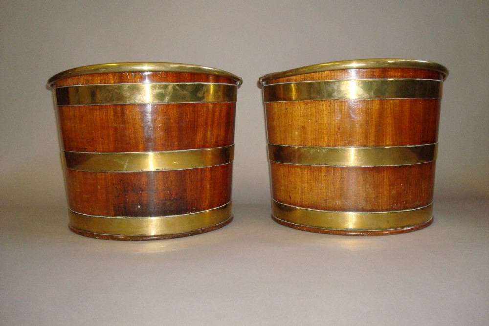 A pair of 18th-century mahogany plate buckets featuring brass binding straps, swing handles, and a vertical front cutout. View IV
