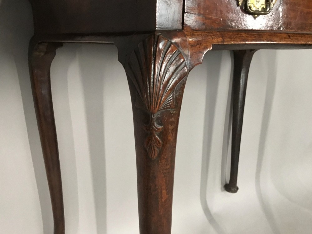A George II dark walnut side table featuring carved shell knees on slender cabriole legs with pad feet and a single drawer with brass handles. View XII