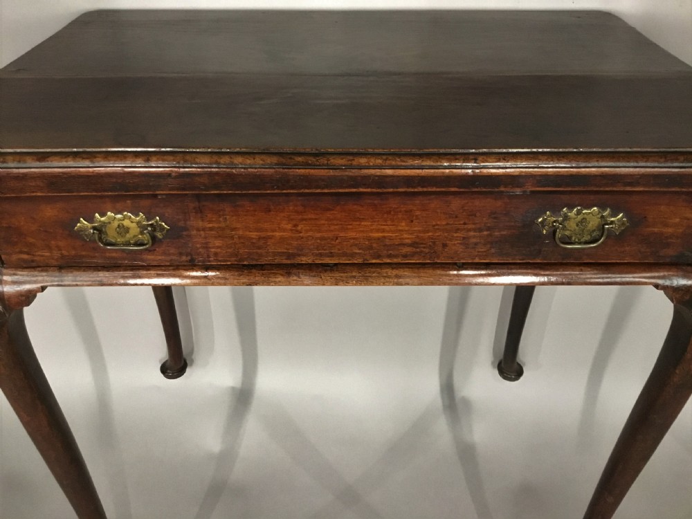A George II dark walnut side table featuring carved shell knees on slender cabriole legs with pad feet and a single drawer with brass handles. View XIII