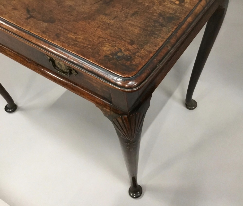 A George II dark walnut side table featuring carved shell knees on slender cabriole legs with pad feet and a single drawer with brass handles. View XV